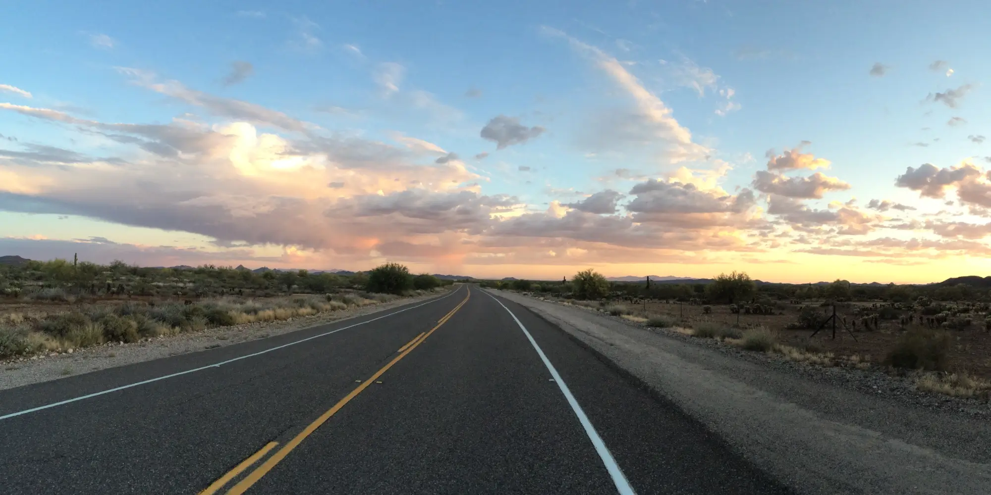 Open desert road beneath an Arizona sunset